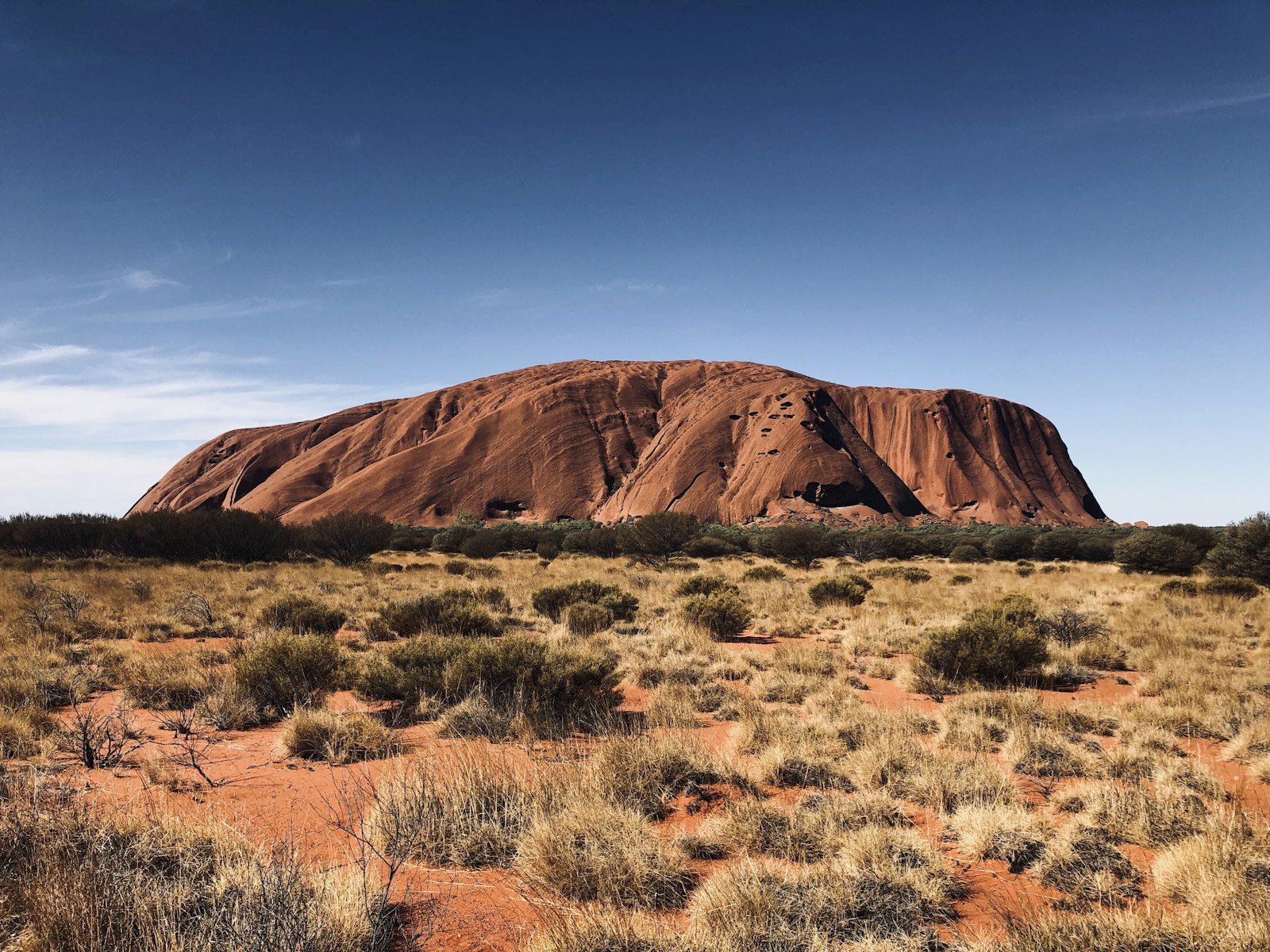 Uluru rising above the desert scrubland in the Northern Territory, Australia